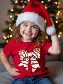 SHEIN Camiseta básica de manga corta con estampado gráfico de lazo de lunares, lema navideño y diseño de dibujos animados lindo y elegante para niña, cómoda para fiestas de Navidad y salidas
