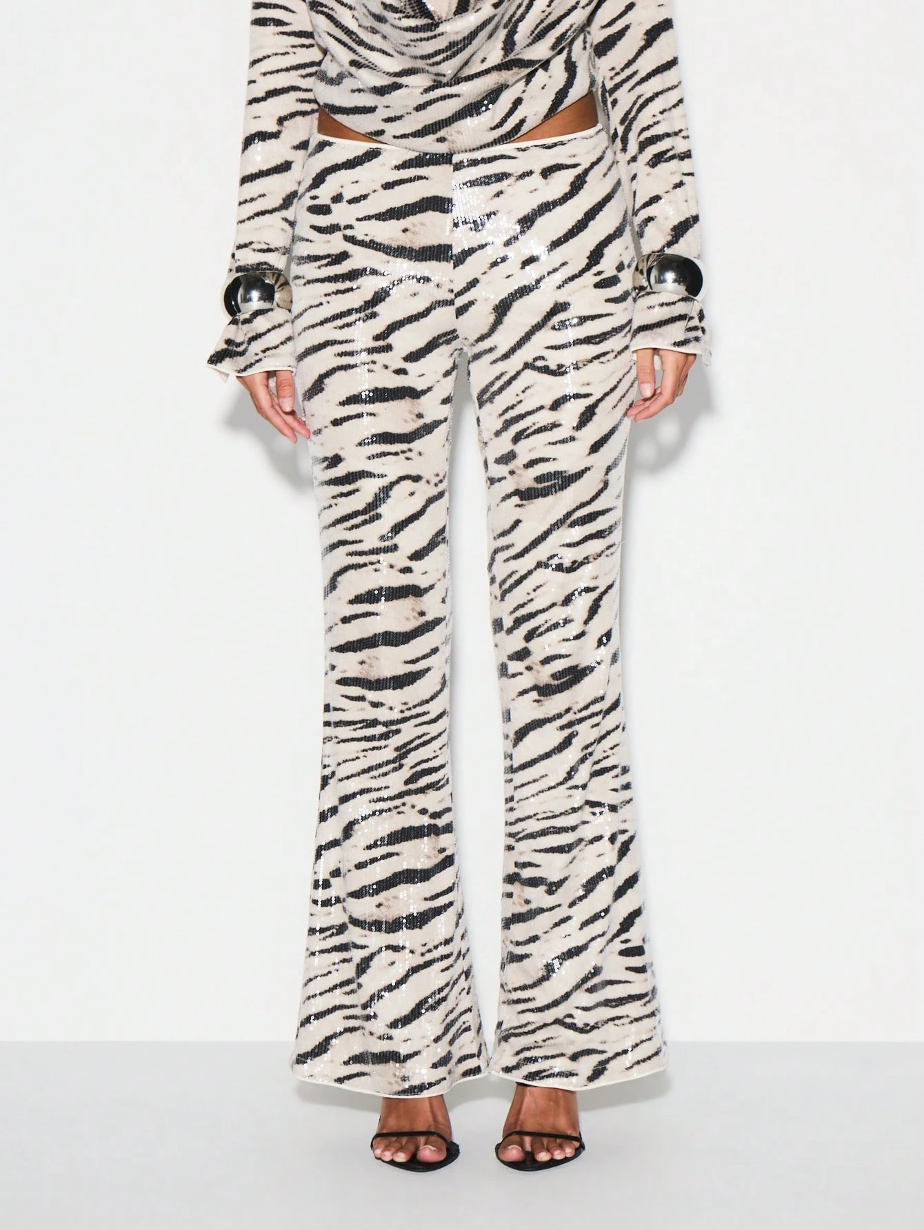 KIZN Calça flare com estampa de zebra e lantejoulas e bainha franzida