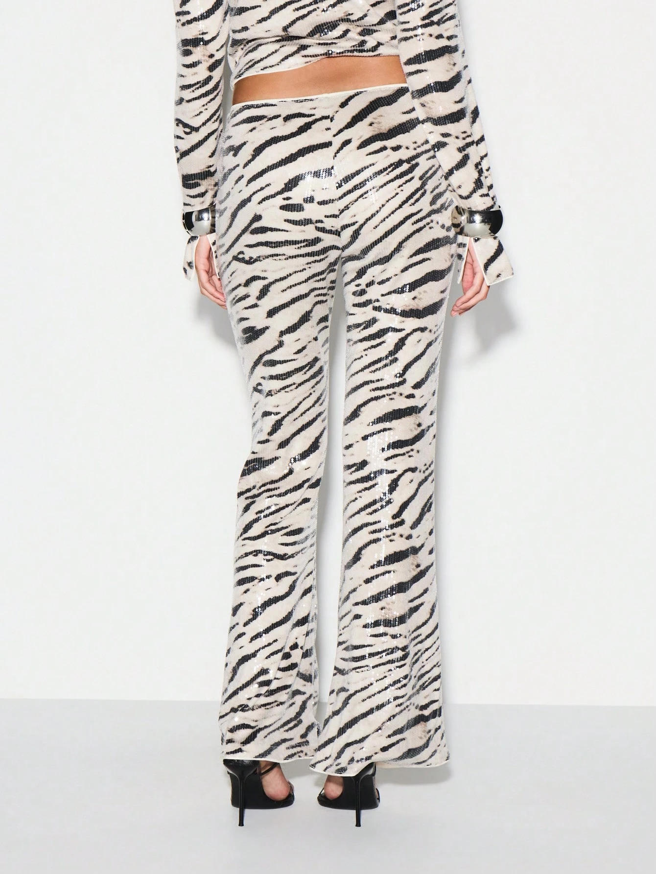 KIZN Calça flare com estampa de zebra e lantejoulas e bainha franzida
