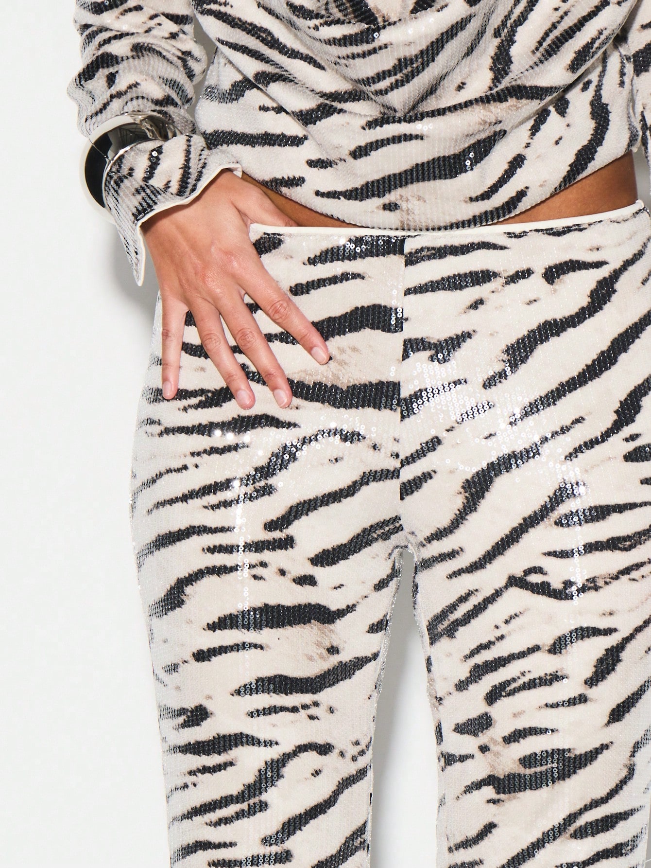 KIZN Calça flare com estampa de zebra e lantejoulas e bainha franzida