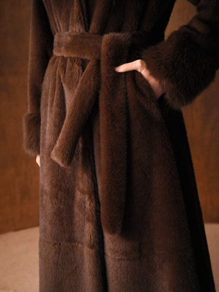 Elegante cappotto lungo con maniche lunghe, cintura in vita e colletto in pelliccia sintetica, adatto per l'autunno/inverno