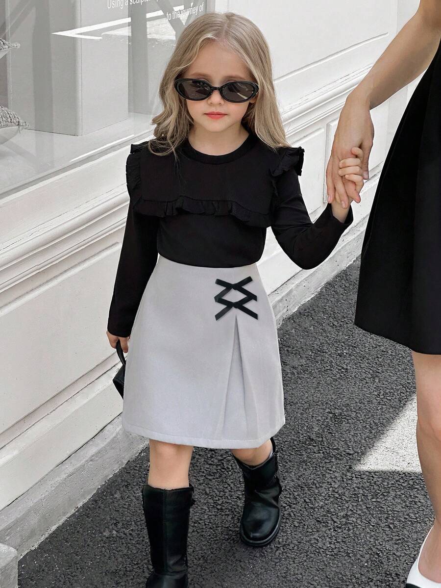 SHEIN Elladie kids Conjunto de camiseta de manga larga acanalada negra linda con falda con decoración de lazo y bajo dividido para niñas, conjunto de camiseta de otoño/invierno - Negro - Ver 1