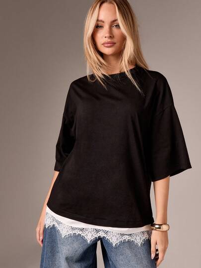 AiiRZ Top noir oversize avec détail d'ourlet en dentelle blanche, manches courtes, coupe décontractée