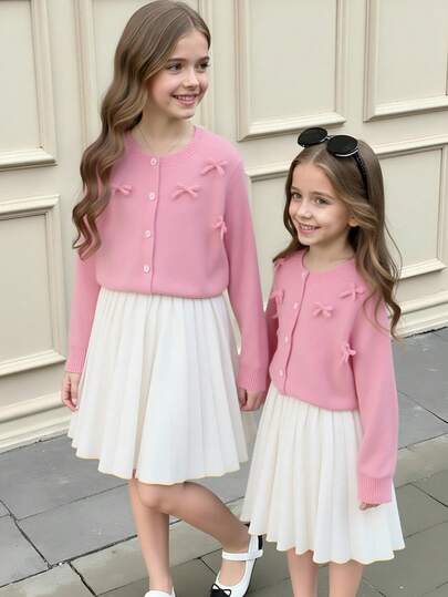 少女时尚粉色蝴蝶结针织开衫搭配百褶迷你裙，适合居家、外出、派对、返校