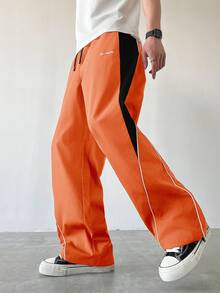 Manfinity EMRG Męskie spodnie dresowe w swobodnym stylu z kolorowymi blokami, ściągaczem i prostymi nogawkami, luźne, długie, patchworkowe, czarne, proste nogawki, spodnie Manfinity Hypemode, wiatrówki, pomarańczowe, spodnie dresowe, męskie, szerokie nogawki, z bocznymi paskami, spodnie sportowe, Streetwear - Pomarańczowy - Zobacz 4