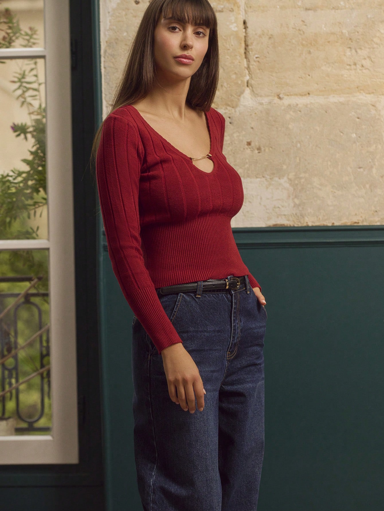 Top tricoté rouille avec encolure en V profonde ornée d'un anneau doré et manches longues ajustées, chic pour l'automne-hiver