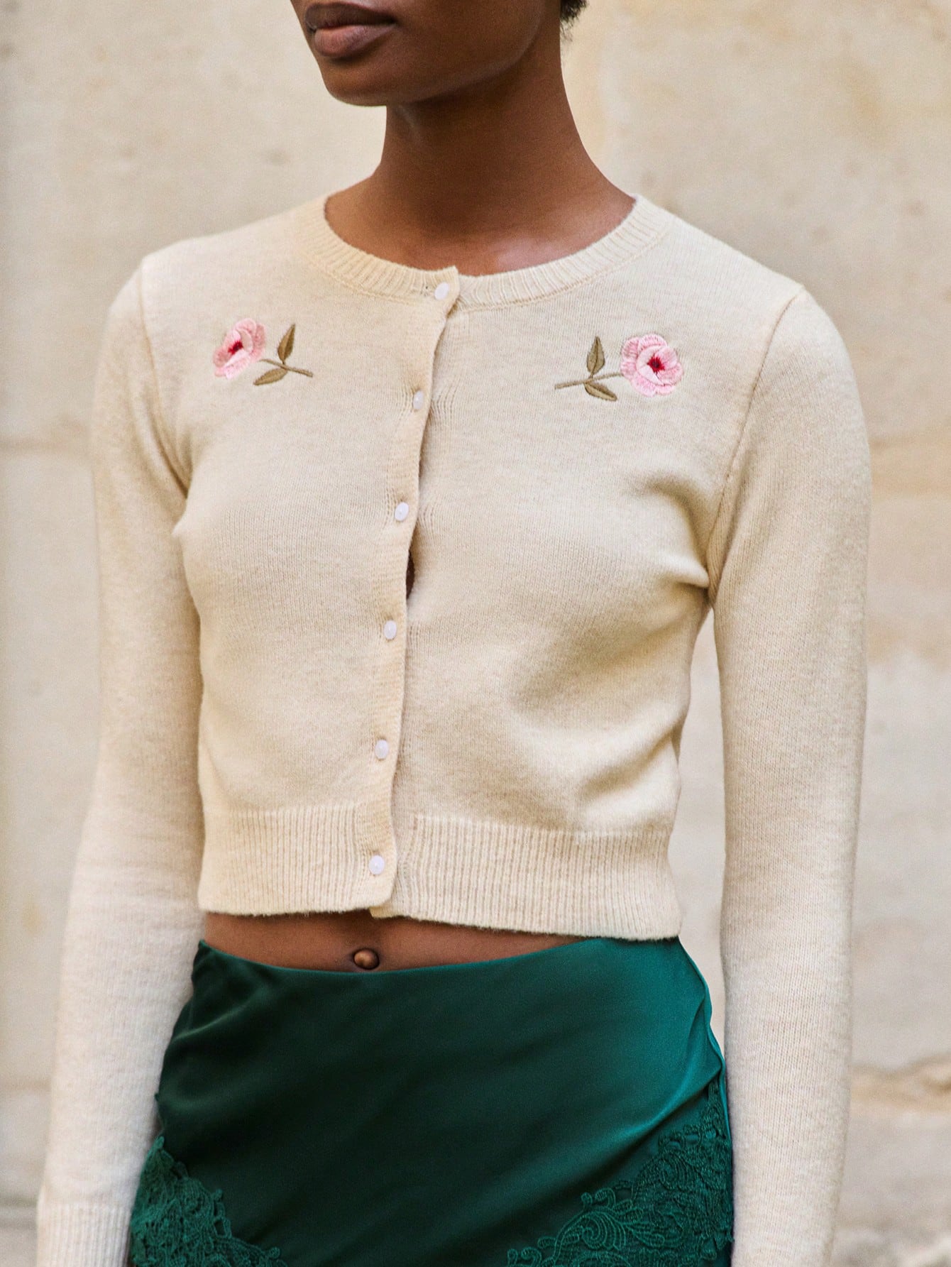 Beżowy dzianinowy kardigan z haftowanymi różami i zapięciem na guziki z przodu, wygodny na jesień i zimę
