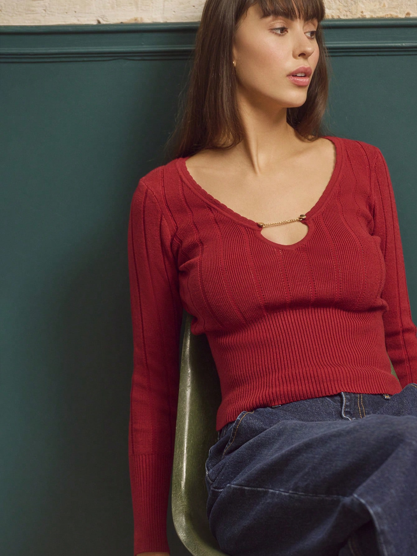 Top tricoté rouille avec encolure en V profonde ornée d'un anneau doré et manches longues ajustées, chic pour l'automne-hiver