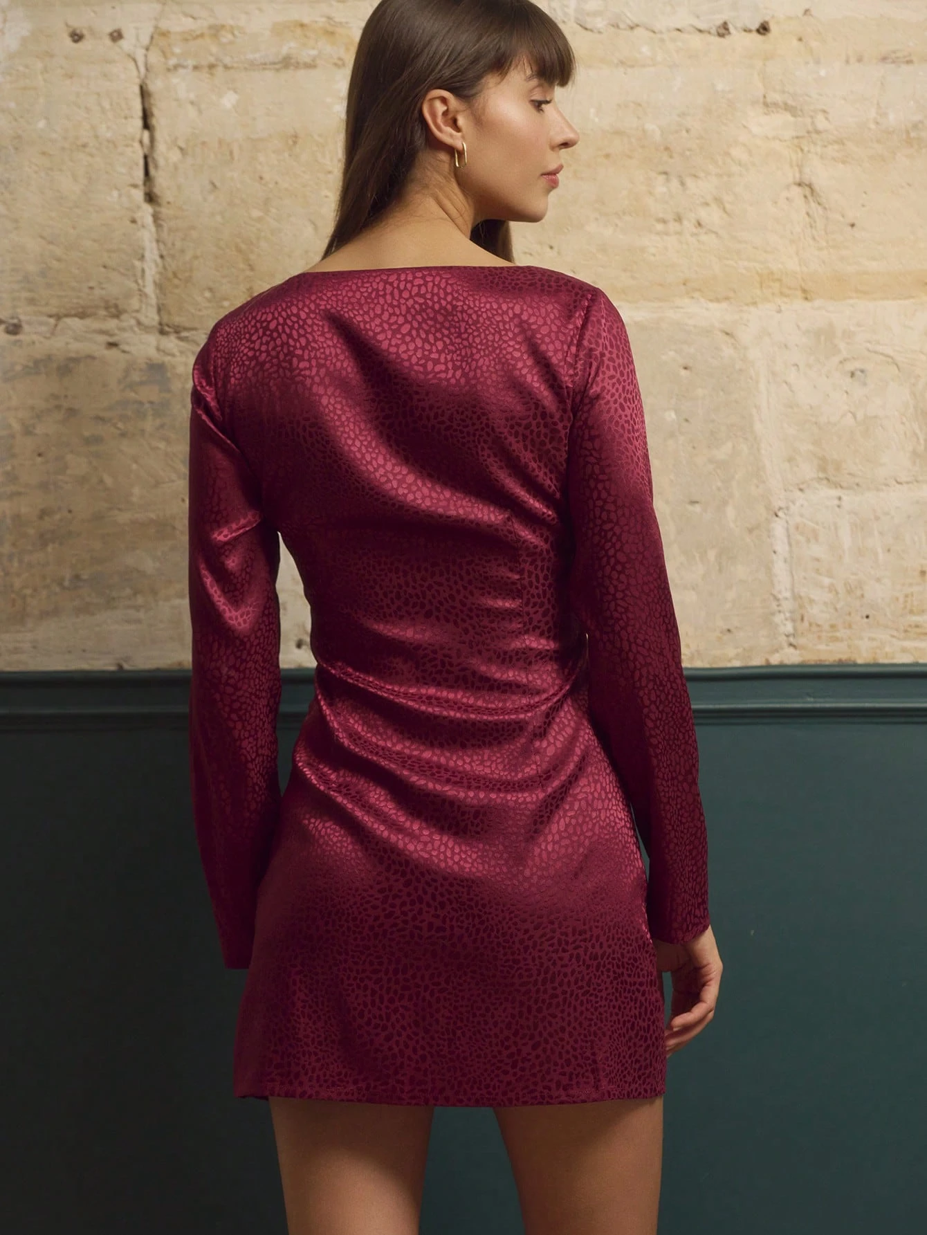 Robe mini ajustée en satin jacquard bordeaux avec découpe au niveau du décolleté et manches longues, élégante pour l'automne et l'hiver