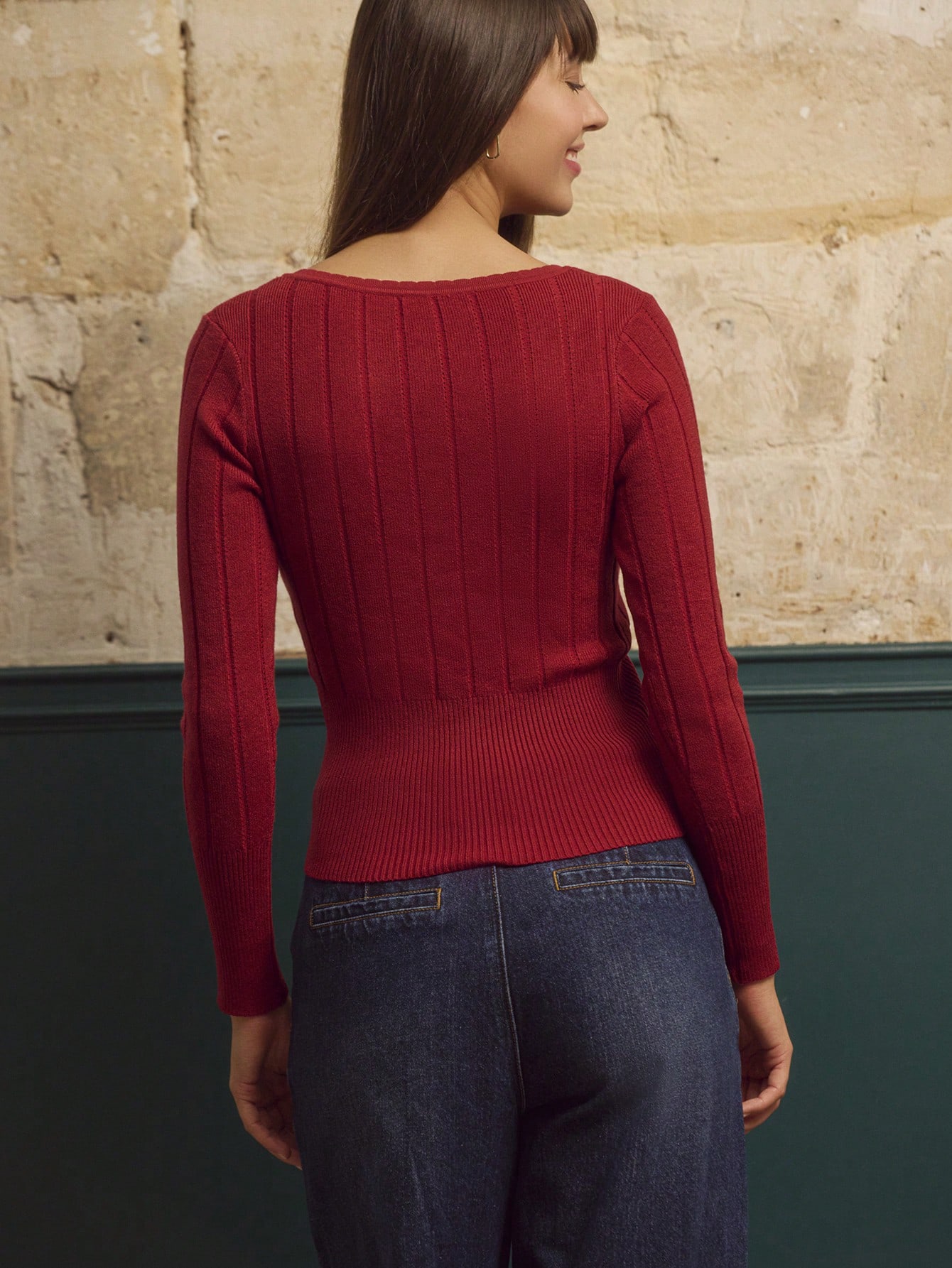 Top tricoté rouille avec encolure en V profonde ornée d'un anneau doré et manches longues ajustées, chic pour l'automne-hiver