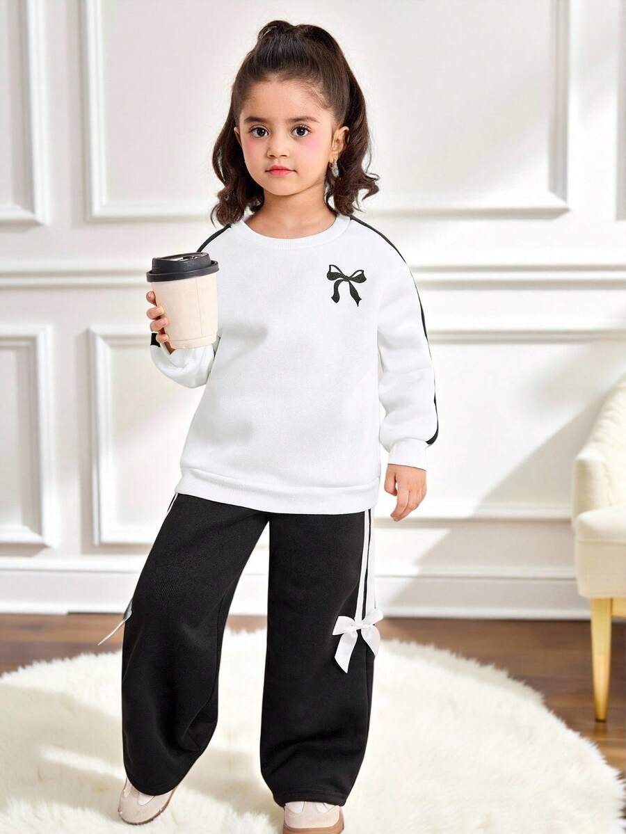 SHEIN Bộ 2 món/Bộ trang phục thể thao thường ngày cho bé gái, áo nỉ in nơ ruy băng tay dài cổ tròn màu tương phản, dáng rộng và quần ống đứng có trang trí nơ 3D, trang phục trở lại trường, đen trắng - Đen và trắng - Xem 1