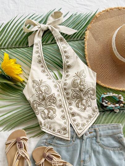 Soleia Top corto con cuello halter, espalda descubierta y lazo, con bordado floral sobre base color albaricoque, adecuado para festivales de música