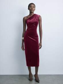 Maija Vestido feminino de veludo bordô liso com ombros assimétricos e cintura marcada, ideal para o dia a dia urbano, negócios e ocasiões casuais. Perfeito para festas de Natal e Ano Novo.
