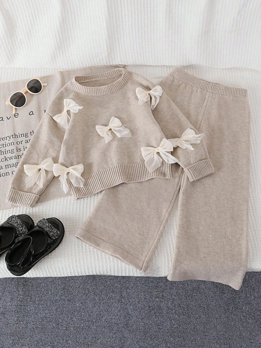 SHEIN Playful Pals Baby Girls Sweater Co-Ords, Champagne Color, Handmade 3D Bow Decor Round Neck Pullover Sweater And Wide Leg Pants Knit Set, Soft And Comfortable, Suitable For Daily, Outdoor, Travel, Vacation, Home, Daycare And Baby Girl Play Wear, Autumn/Winter Bow Baby Clothes Baby Girl Sweaters Set Beige Baby Girl Clothes Elegant Tops For Baby Girl Knit Two Pieces - Apricot - View 1