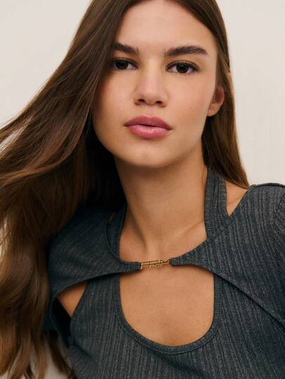 Nöista 这款灰色上衣采用现代感十足的挂脖领设计，饰有金属扣环，并带有低调的闪光。长袖设计和修身剪裁，使其成为春假聚会、生日派对、女士活动或时尚优雅女士装扮的完美之选。