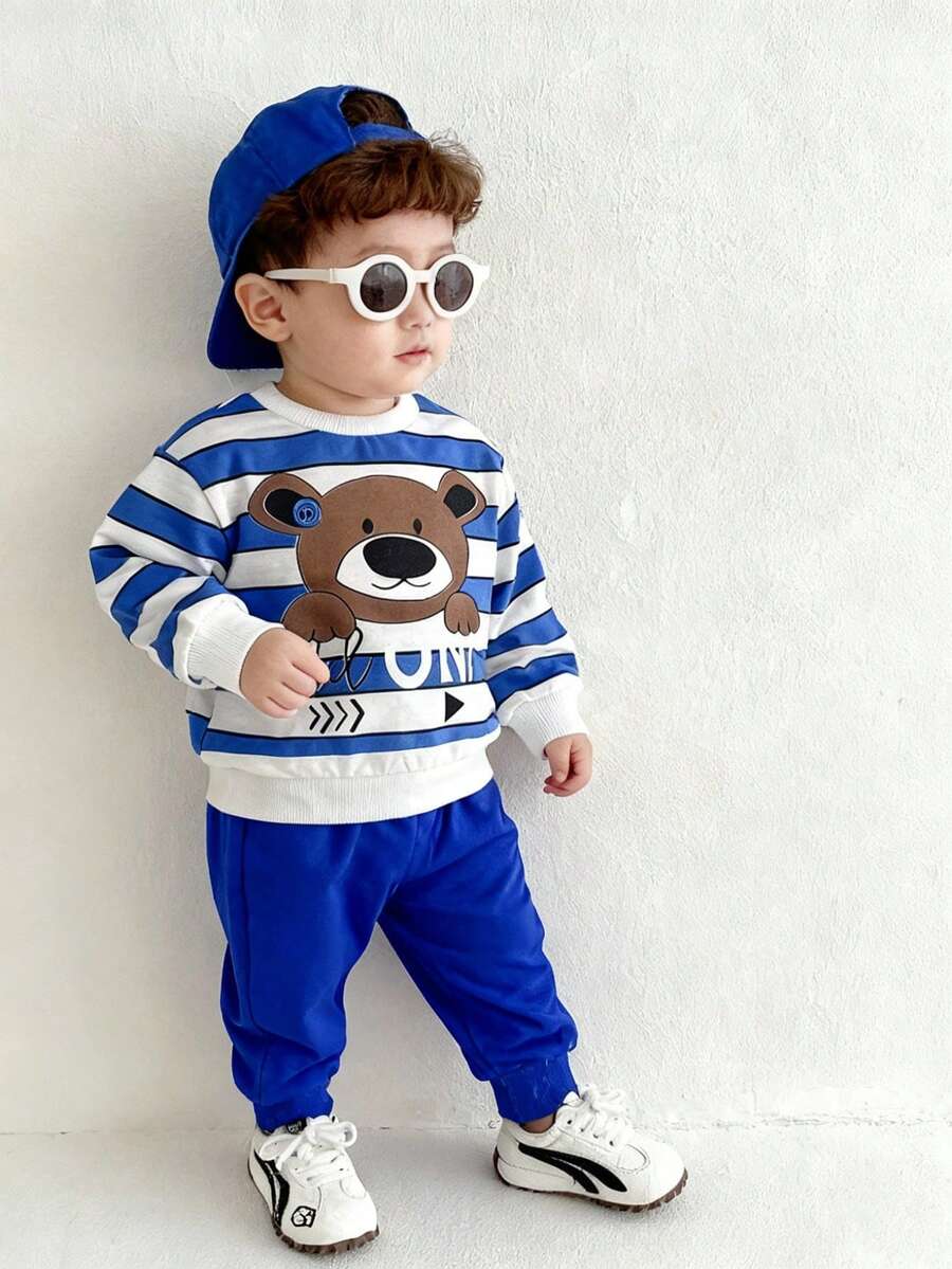 SHEIN Playful Pals 2 Stück/Set Kleinkind/Säugling Kinder Cartoon Bär Muster blau & weiß gestreifter Sweatshirt und Hose Set, geeignet für Herbst/Winter, Säuglingssportoutfit Set, Säuglings blauer Sportanzug Set, Säuglings/Baby Jungen Winterbekleidung, Säuglings/Baby Jungen Streetwear Set, 6M-3T Säuglings/Baby Jungen Sportanzug Set, Baby Jungen Streetwear, Säuglings/Baby Jungen Bekleidung, Jungen Sportanzug Set, Säuglings/Baby Jungen Streetwear blauer Outfit Baby Jungen Baby Lässig Outfit Baby Jungen Trainingsanzug - Blau - Übersicht 1