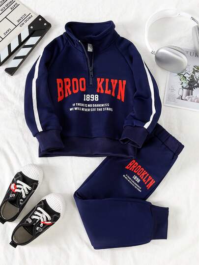 Ung pojke med bokstavstryck och dragkedja i pikétröja och byxor, avslappnad outfit