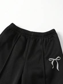 SHEIN Genkimix Kids 两件套女童返校休闲简约卫衣套装。正面饰有黑色铆钉蝴蝶结，灰色罗纹袖口、领口和下摆。灰色纯色针织圆领长袖卫衣搭配灰色蝴蝶结印花黑色针织长裤。适合秋冬季返校季，可爱简约的韩版风格，日常穿着、上学、旅行、聚会、圣诞节等场合皆宜。 - 彩色 - 查看 4