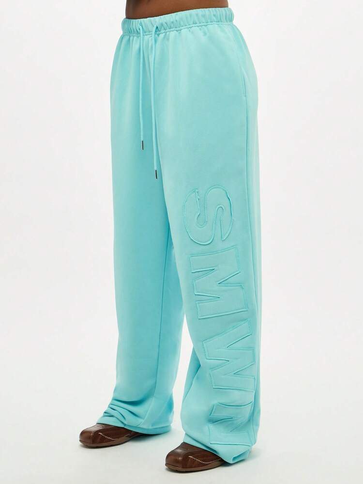 Pantalon de survêtement à cordon de serrage avec inscription en relief