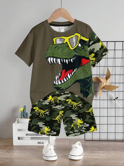 SHEIN Conjunto de 2 piezas de camiseta de manga corta con cuello redondo y pantalones cortos con estampado de dinosaurios de dibujos animados para niños pequeños, verano