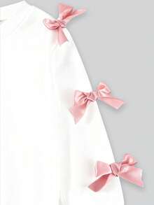 SHEIN 两件套女童甜美酷炫3D蝴蝶结装饰白色上衣+黑色喇叭裤套装，黑色上衣饰有多个粉色蝴蝶结，搭配时尚的紫红色喇叭裤，甜美时尚，适合返校、外出、街头风格。