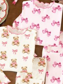 SHEIN Conjunto de pijamas de invierno para niñas con estampado de lazo rosa y corazón, estampado de oso con lazo rosa, lazo rosa y cinta, cómodo y fácil de usar, adecuado para la temporada de invierno, Navidad, otoño e invierno, con tops gráficos casuales y de estilo nuevo para bebés y niños