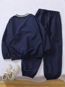 Genkimix Kids 新款活力男童宽松V领长袖字母印花T恤搭配休闲抽绳长裤套装。T恤采用独特的黑白罗纹领口设计，饰以寓意深刻的字母印花，搭配舒适柔软的宽松抽绳长裤。时尚百搭又实用，非常适合男孩日常上学、社区活动、购物等各种场合穿着。 - 藏蓝色 - 查看 2