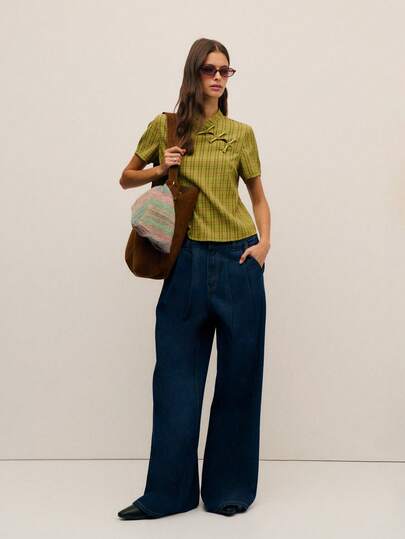 Nöista Esta blusa femenina presenta un cuello alto con elementos inspirados en la cultura china. Tres botones le dan un toque oriental. La silueta recta de manga corta y el corte limpio mejoran la comodidad y le dan un aspecto casual. El estampado de cuadros crea un ambiente retro y colegial con un toque casual y cotidiano. Es perfecta para salidas casuales, reuniones con amigos, eventos culturales y talla grande, y se puede integrar fácilmente en un estilo ligeramente retro o dulce.