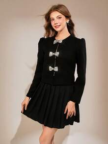这款别致的黑色两件套专为 13-16 岁的女孩设计：包括一件挺括厚实的长袖上衣，饰有引人注目的亮片蝴蝶结，以及一条永不过时的百褶裙。 - 黑色 - 查看 4