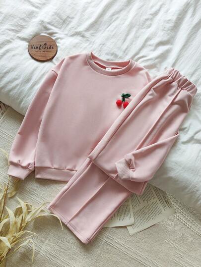Vintaside Kids Tween Girls Detta tvådelade set med rosa rundhalsad tröja med bara axelband och raka långa byxor i en avslappnad och söt höst- och vinterstil har en tredimensionell körsbärsdekoration på bröstet. Med en lös passform och stickat tyg har det en enkel, söt och gullig stil. Det är lämpligt för avkoppling hemma, skoldagar,