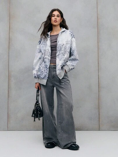 TypaGal بلوزة رياضية بيضاء ورمادية مع طباعة نمر وكتابات بأسلوب جوثي. مزيج جريء من الشارع والأناقة.