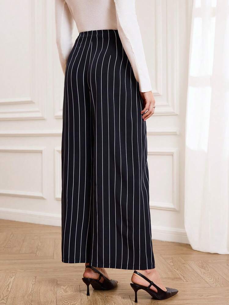 These Elegant Women's Trousers Feature A Sophisticated Navy Blue Base With White Vertical Stripes, Perfectly Complementing The Refined Atmosphere Of The New Year While Exuding A Sleek And Stylish Feel. The Simple Vertical Stripe Pattern Visually Elongates The Legs And Adds A Touch Of Sophistication. The High-Waisted, Wide-Leg Design, Adorned With Gold Buttons For Added Detail And Quality, Offers Both Comfort And A Flattering Silhouette. Suitable For Spring And Autumn, These Trousers Can Be Paired With A White Top For An Elegant Look Or Layered With A Jacket For Added Depth. Perfect For Both Work Commutes And Casual Gatherings, These Trousers Showcase Professional Style At Work While Also Highlighting A Polished And Sophisticated Taste Thanks To Their Striped Design. A Versatile And Stylish Addition To Any New Year's Wardrobe, These Trousers Are Both Practical And Chic.