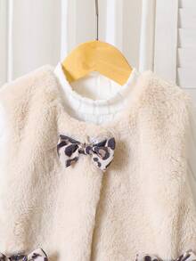 Kleine Mädchen Vintage Chic Outfit bestehend aus cremefarbener Kunstfell Weste, Leoparden Cord Rock und weißem Rollkragenpullover. Die Weste besteht aus weichem Kunstfell mit Leoparden Muster Schleife und Tasche. Der Cord Rock ist komplett mit Leoparden Muster. Dieses modische Retro-Stil Outfit ist geeignet für Wochenendausflüge, Familienrestaurants usw. Die Kombination aus Kunstfell und Cord bietet ausreichend Wärme für die Herbst-/Wintersaison.