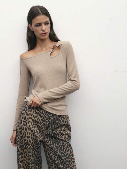 Nöista 浅棕色不对称领长袖上衣，金属扣环闭合，自信的街头风格，既能保暖过冬，又能提升节日氛围，打造圣诞节或新年活动的造型；是当季的现代百搭之选。