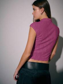 Nöista Áo kiểu mùa thu này mang vẻ ngoài tươi tắn và ngọt ngào, lấy cảm hứng từ kiểu áo sườn xám Trung Quốc hiện đại, với phom dáng ôm sát. Cổ áo đứng được trang trí bằng cúc áo, làm nổi bật nét quyến rũ truyền thống. Các đường cắt bất đối xứng tạo thêm điểm nhấn và đường nét nữ tính. Gấu áo được thuôn nhẹ và gợn sóng tự nhiên, tạo cảm giác nhẹ nhàng. - Hồng - Xem 6