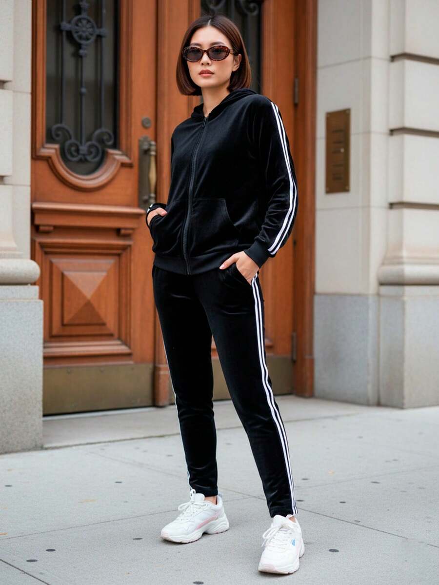 Conjunto de pants deportivo y casual para mujer, colores lisos, con líneas verticales en los laterales, tela tipo terciopelo de poliéster y spandex. pants sin bolsillos de ajuste regular con bota semi-entubada, talle de cintura natural. Sudadera deportiva, cuello redondo con capucha, silueta de ajuste regular, cierre con cremallera y bolsillos frontales tipo canguro funcionales. Muy fresco y cómodo, ideal para hacer deporte al aire libre, caminata en el parque o para ir al gimnasio. - Negro - Ver 1