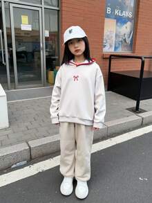 这款浅灰色女童连帽卫衣，饰有红色蝴蝶结刺绣和精致滚边，是一款可爱的长袖套头衫，适合儿童穿着。面料柔软舒适，设计休闲百搭，为少女带来温暖的穿着体验。 - 淺灰色 - 查看 4