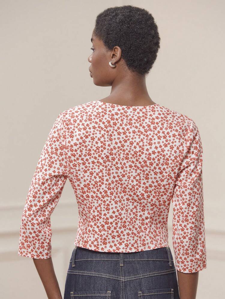 Blusa con stampa floreale rossa, maniche a 3/4, scollo a V profondo e chiusura con bottoni anteriori, stile carino