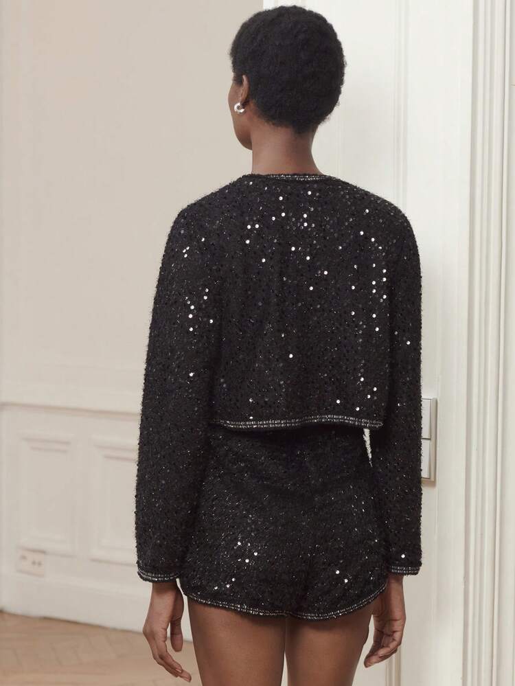 Veste courte style tweed noir avec paillettes subtiles et bordure contrastée - Tenue sophistiquée