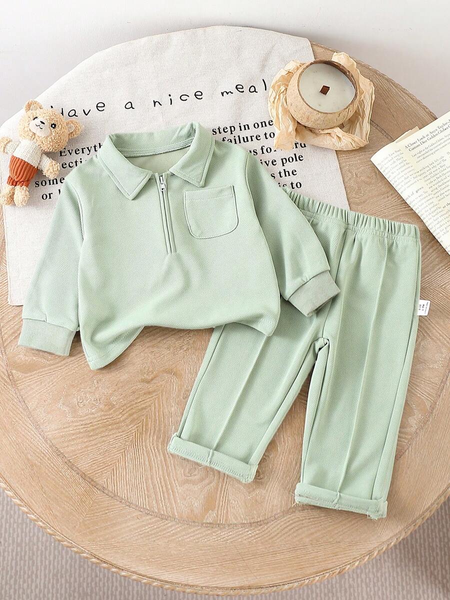 SHEIN Trang phục thường ngày cho bé trai/bé gái, với bảng màu ấm áp và phong cách tối giản thanh lịch. Ấm áp và thoải mái cho mùa hơi se lạnh. Áo dài tay cổ bẻ, khóa kéo nửa màu trơn, thiết kế dễ mặc; kết hợp với quần cạp trễ màu trơn. Thích hợp cho việc đi dạo, giải trí, tập thể dục nhẹ nhàng hoặc những buổi họp mặt gia đình ấm cúng, giúp bé yêu của bạn tỏa sáng với nét duyên dáng và sức sống trẻ thơ. - màu xanh lá - Xem 1