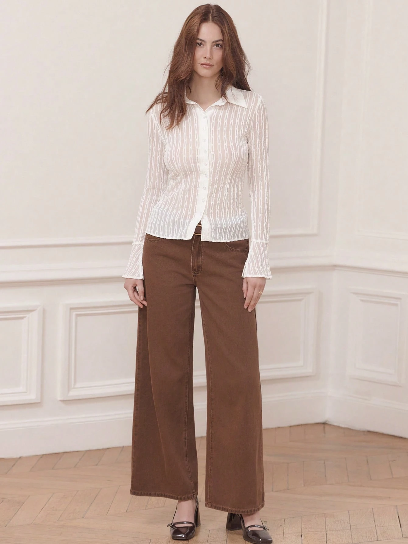 Camisa blanca ajustada y transparente con tela texturizada y puños acampanados