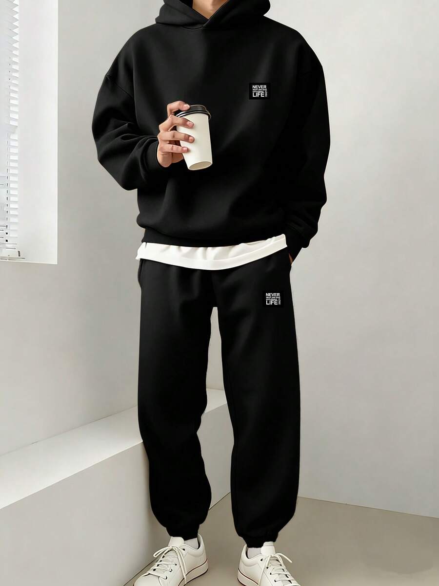 Chillumni 男士两件套:“永不言败,继续探索人生。”标语贴片经典黑色连帽衫和宽松黑色运动裤,休闲运动套装,保暖内衬。 - 黑色 - 查看 1