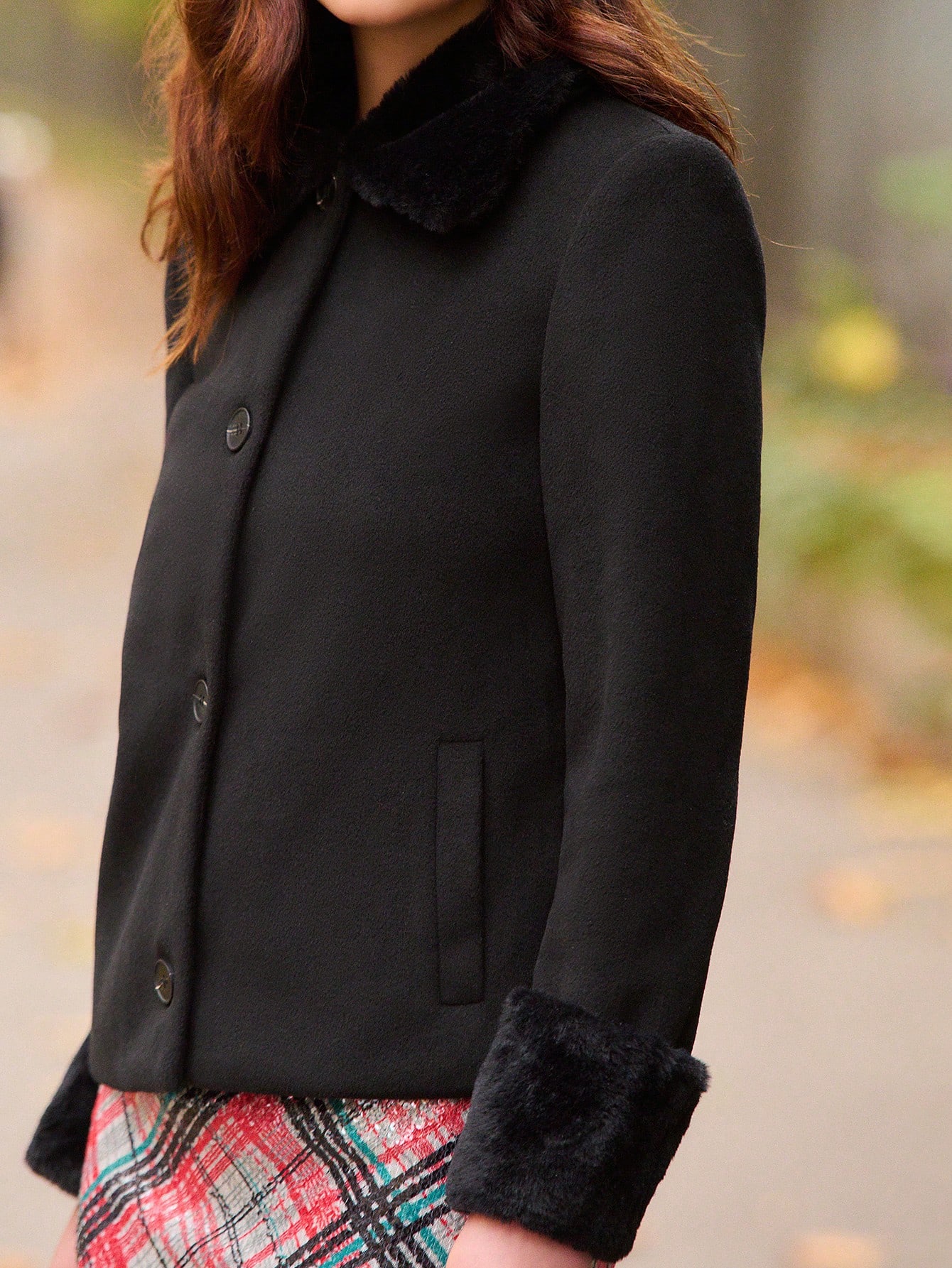 Czarny płaszcz z kołnierzem i mankietami ze sztucznego futra – szykowna zimowa odzież wierzchnia