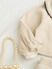 SHEIN 两件套女宝宝可爱甜美学院风时尚米色纯色罗纹纹理撞色黑色包边彼得潘领三蝴蝶结装饰长袖T恤套头衫和松紧腰A字裙两件套，柔软舒适，适合日常穿着、学校活动、秋冬季节。 - 白色 - 查看 7