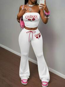 Slaydiva مجموعة بنطلون وكروب توب من قطعتين للنساء، تتكون من: كروب توب أكتاف بارزة ضيق من قماش مضفر وردي مع طباعة حرفية وفواكه كرز، مقترن مع بنطلون ضيق بخصر مطاطي وربطة حبل أحمر بطبعة الكرز، بأسلوب بوهيمي عصري مناسب للحفلات والشاطئ والأعياد، موديل ربيع/صيف 2025