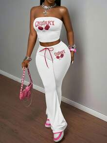 Slaydiva مجموعة بنطلون وكروب توب من قطعتين للنساء، تتكون من: كروب توب أكتاف بارزة ضيق من قماش مضفر وردي مع طباعة حرفية وفواكه كرز، مقترن مع بنطلون ضيق بخصر مطاطي وربطة حبل أحمر بطبعة الكرز، بأسلوب بوهيمي عصري مناسب للحفلات والشاطئ والأعياد، موديل ربيع/صيف 2025