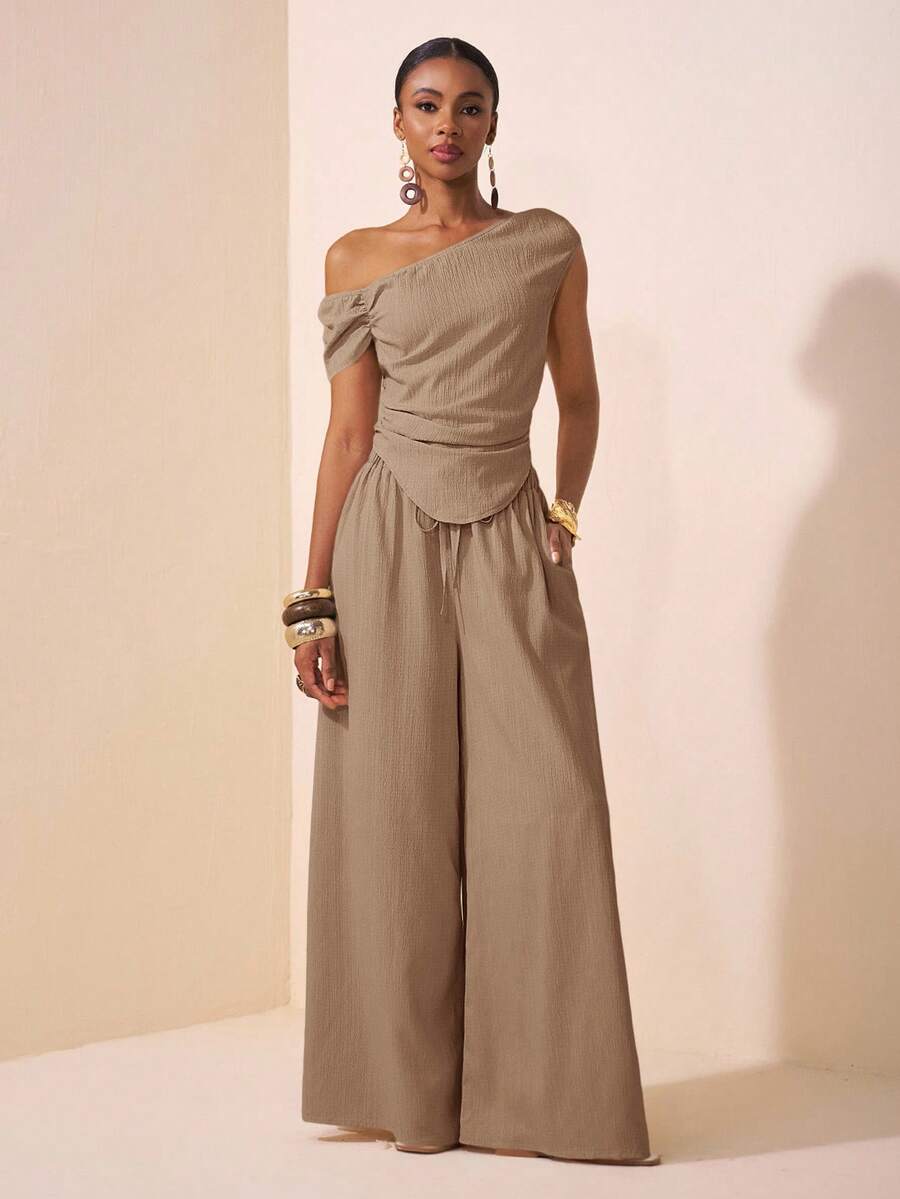 Zivah 2025春夏新款音乐节、复活节、圣帕特里克节、西部风、游牧风、生日派对、毕业典礼、学院风、学生装、日常休闲、百搭、休闲、邮轮旅行、海滩、日光浴、爆款、街头风、婚礼宾客波西米亚风、通勤、早午餐、机场穿搭杏色不对称肩部褶皱弧形下摆露脐上衣和阔腿裤两件套，带口袋，采用纹理面料。