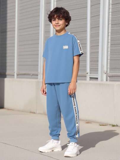 Vacaura 2 件套青少年男孩休闲拼布字母胶带圆领 T 恤和松紧腰字母胶带拼布慢跑裤套装，适合日常穿着