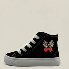 Tenis botín infantiles de tela con gráficos perfectos para actividades escolares, paseos, días casuales y juegos al aire libre. Agujetas blancas y gráficos laterales divertidos, que aportan estilo, dinamismo y personalidad al outfit diario. Fabricados en lona transpirable de alta resistencia, con suela de caucho flexible. Estilo urbano, deportivo y casual, ideal para la temporada Primavera-Verano, combinando fácilmente con jeans, shorts o joggers. Moños tenis de niña - Negro - Ver 3