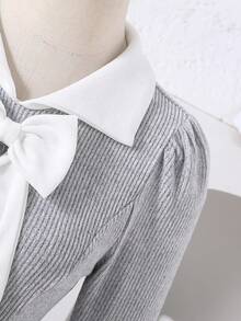 Váy dài tay thu đông cho bé gái tuổi teen được làm từ vải dệt kim gân mềm mại, thân thiện với làn da. Váy có thiết kế cổ Peter Pan màu trắng cổ điển, kết hợp với nơ lớn trang trí cầu kỳ ở ngực. - Xám - Xem 4